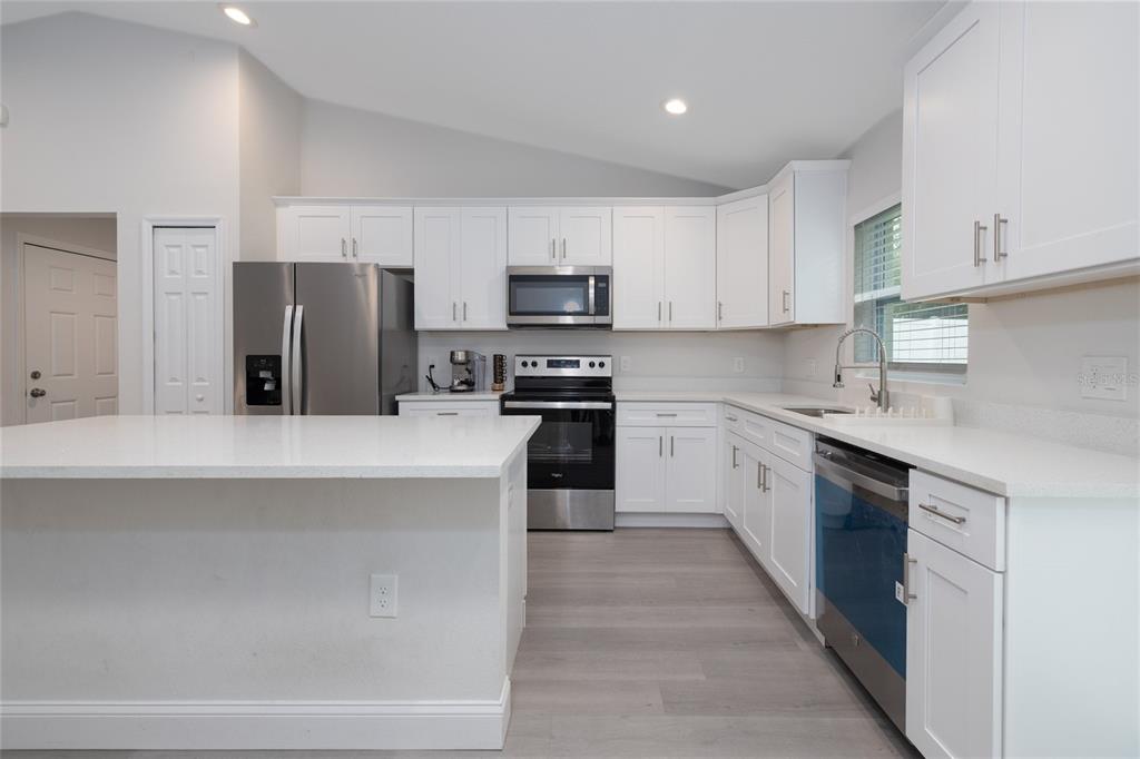 1171 9th Street Orange City, FL 32763 - Photo 15 of 27 a kitchen with kitchen island a refrigerator stove and sink