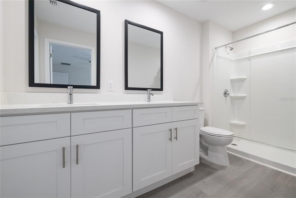 1171 9th Street Orange City, FL 32763 - Photo 25 of 27 a bathroom with a double vanity sink toilet mirror and shower
