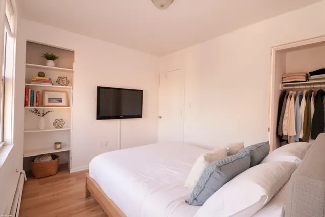 a bedroom with a bed and a flat screen tv