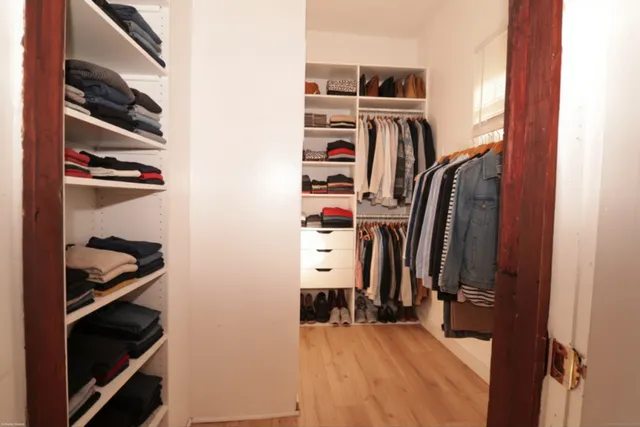 a view of a small space with wooden floor and a window