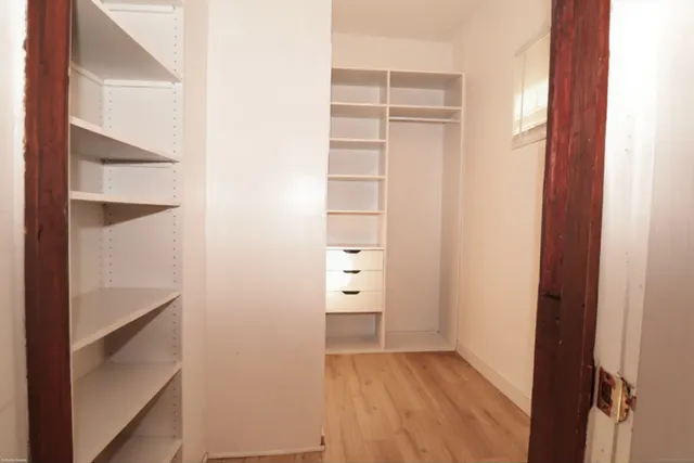 a view of walk in closet with clothes and shoes