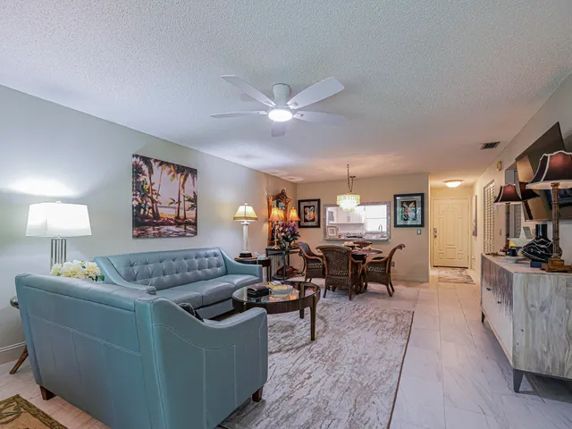 a living room with furniture a lamp and a large window