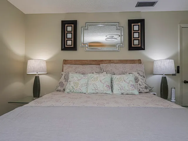 a bedroom with a bed and painting on the wall