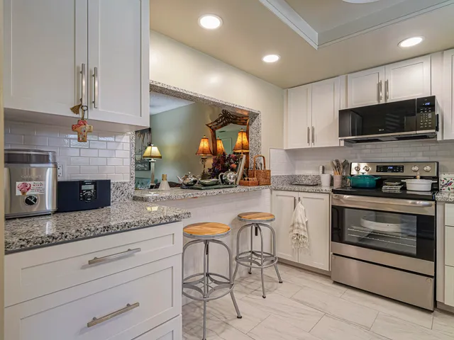 a kitchen with stainless steel appliances granite countertop a refrigerator stove and sink