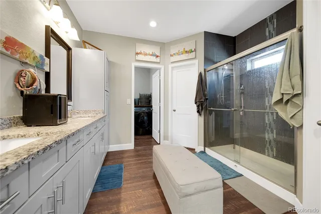 a bathroom with a granite countertop sink mirror bathtub and shower