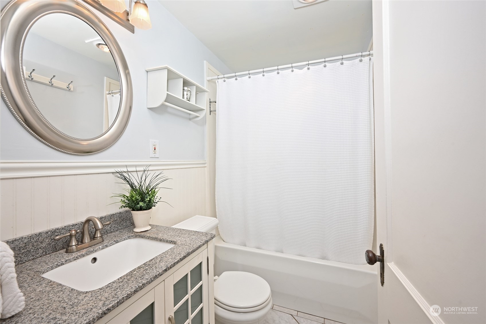 312 Northeast 95th Street Seattle, WA 98115 - Photo 17 of 37 a bathroom with a granite countertop sink toilet a mirror and shower