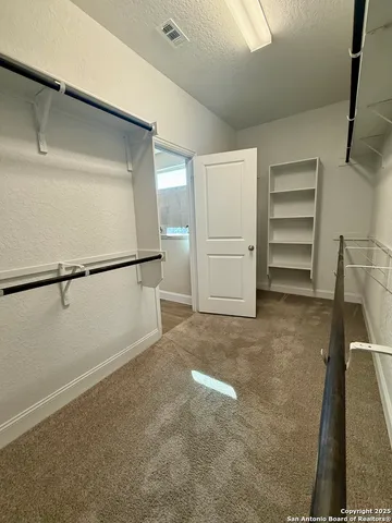 a view of walk in closet with empty racks