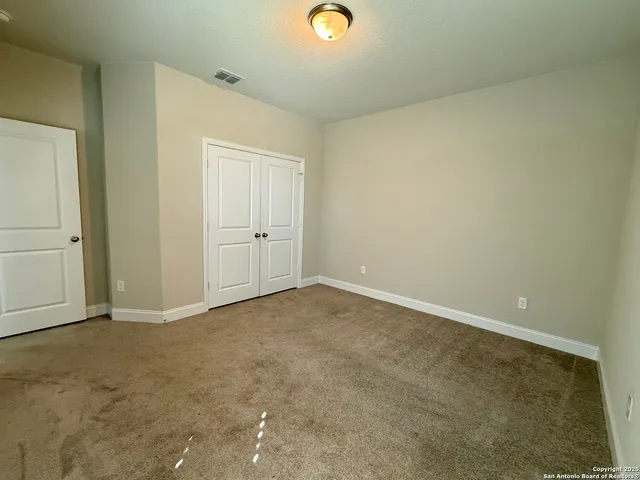 an empty room with closet and windows