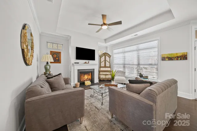 a living room with furniture a fireplace and a large window