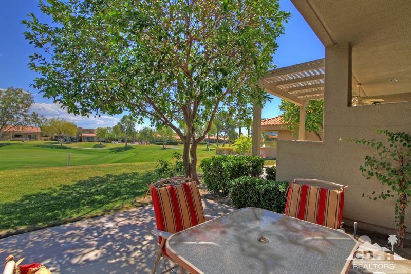 56 Oak Tree Drive Rancho Mirage, CA 92270 - Photo 14 of 32 a view of a backyard with table and chairs potted plants and large tree