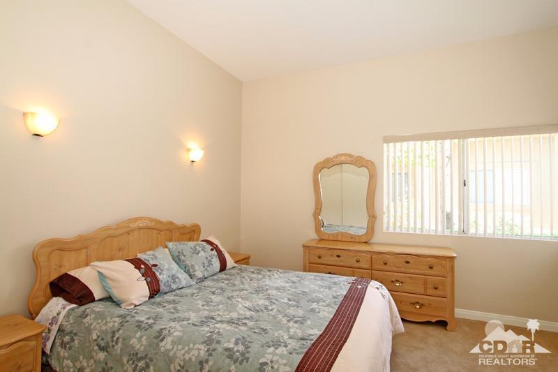 56 Oak Tree Drive Rancho Mirage, CA 92270 - Photo 18 of 32 a bedroom with a bed and dresser with mirror