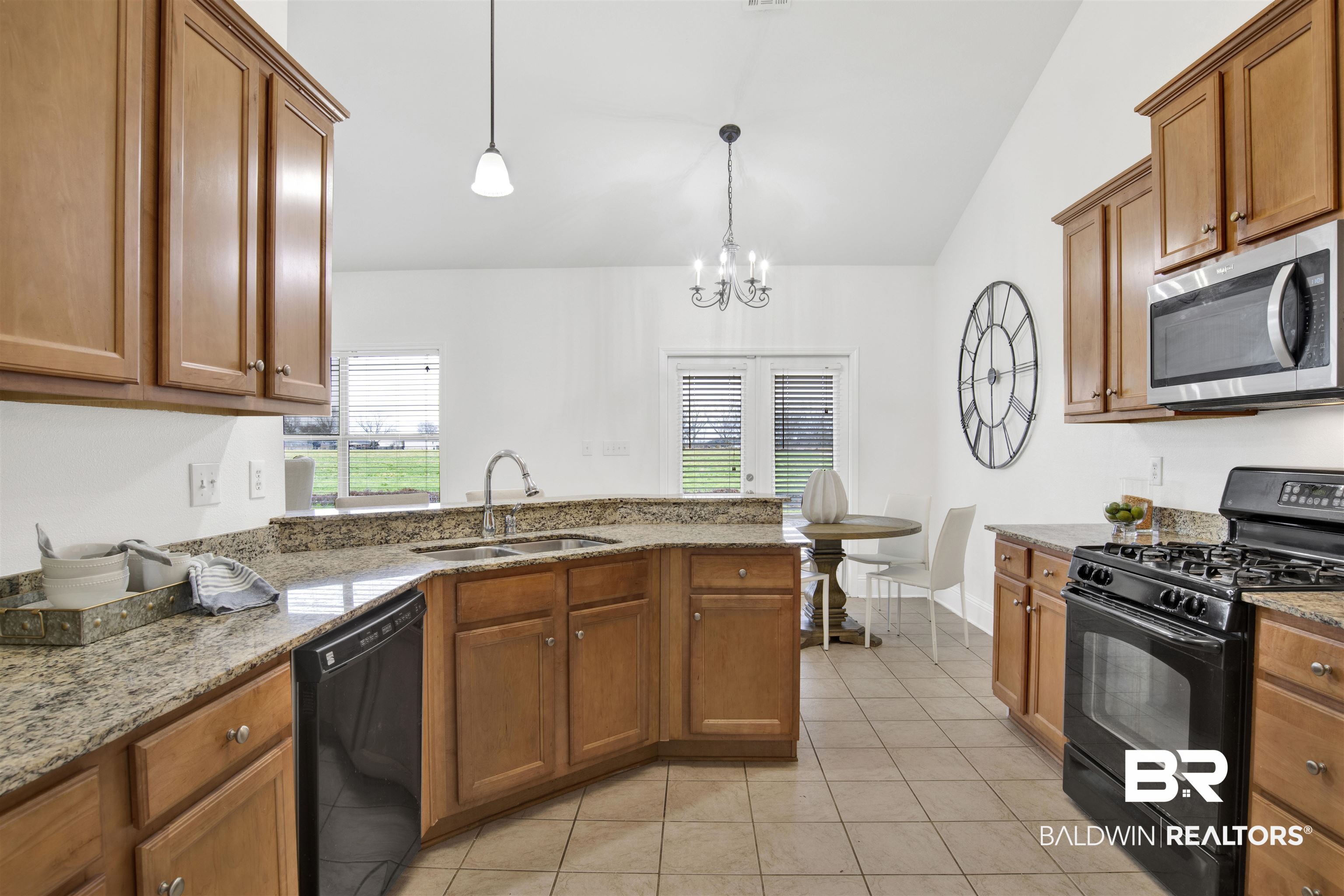 25350 Spindle Lane Daphne, AL 36526 - Photo 15 of 32 Kitchen with decorative light fixtures, sink, light tile patterned floors, light stone counters, and black appliances