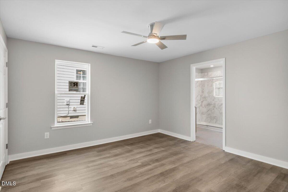 509 Sparella Street Durham, NC 27703 - Photo 20 of 30 an empty room with wooden floor chandelier fan and windows