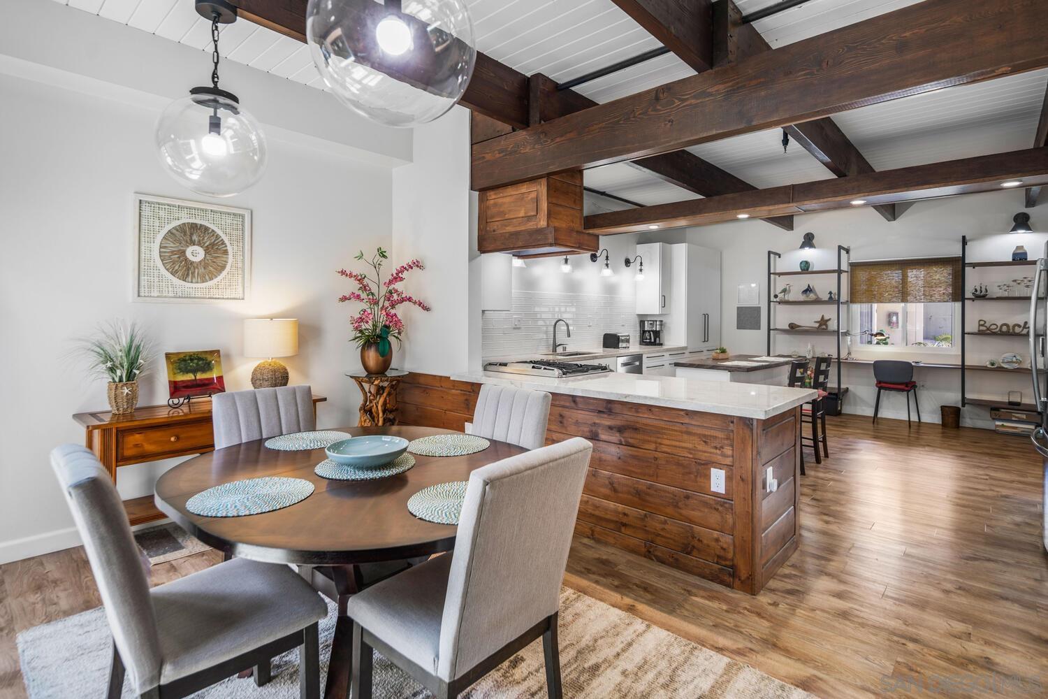 a dining room with stainless steel appliances kitchen island granite countertop a table chairs and a stove