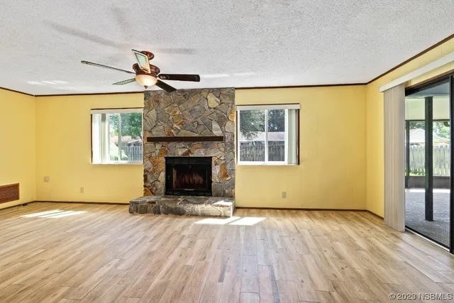 a view of a livingroom with wooden floor a fireplace and windows