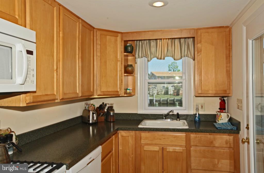 45 Alma Road Long Beach Township, NJ 08006 - Photo 13 of 29 a kitchen with granite countertop a sink a window and cabinets