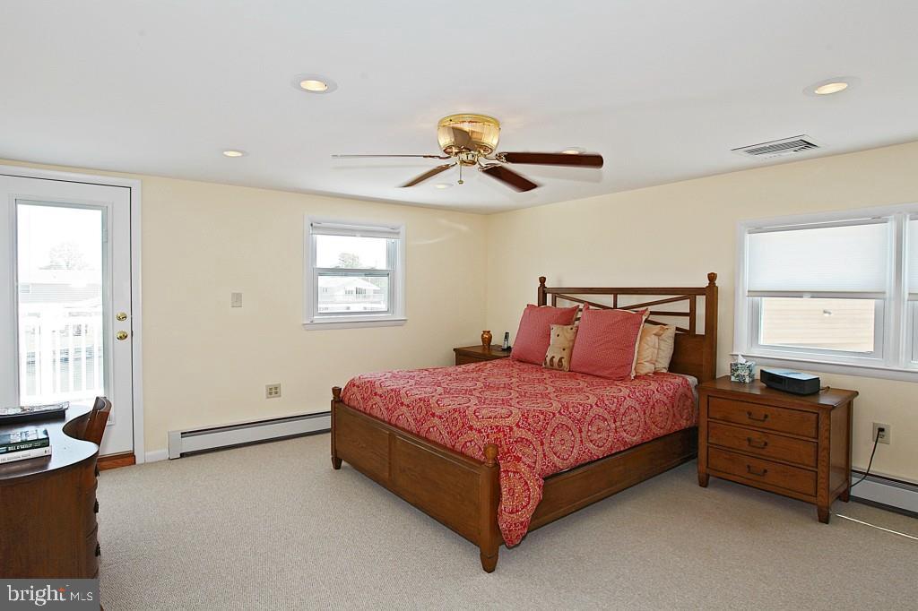 45 Alma Road Long Beach Township, NJ 08006 - Photo 17 of 29 a bedroom with a bed and a chandelier