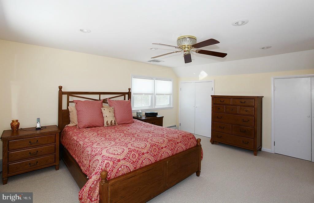 45 Alma Road Long Beach Township, NJ 08006 - Photo 18 of 29 a bedroom with a bed a dresser and a chandelier