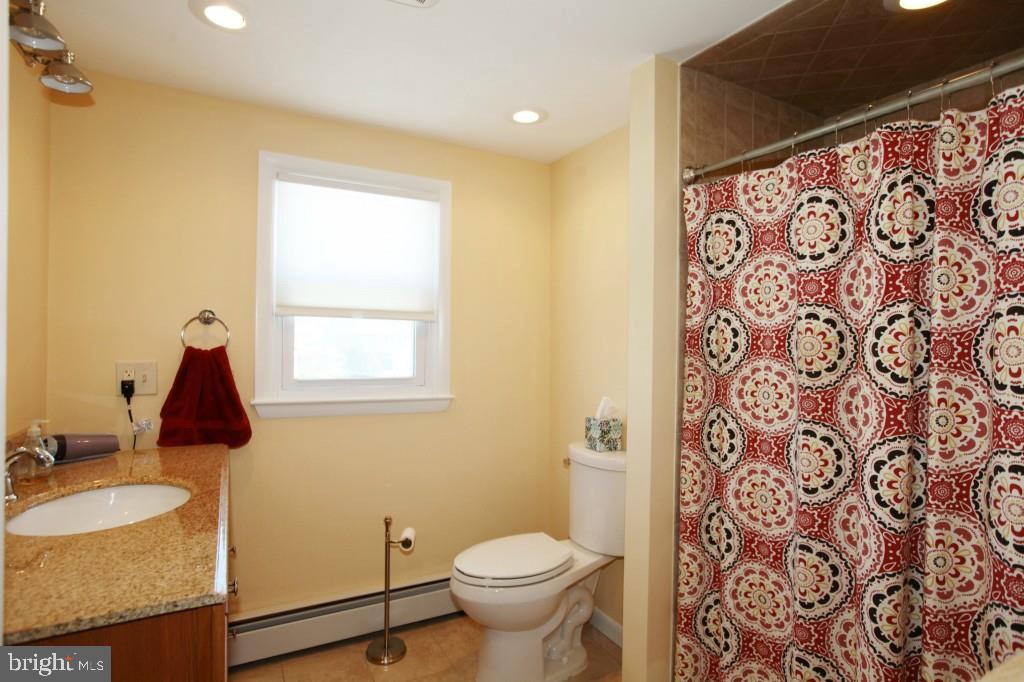 45 Alma Road Long Beach Township, NJ 08006 - Photo 29 of 29 a bathroom with a granite countertop sink and a toilet