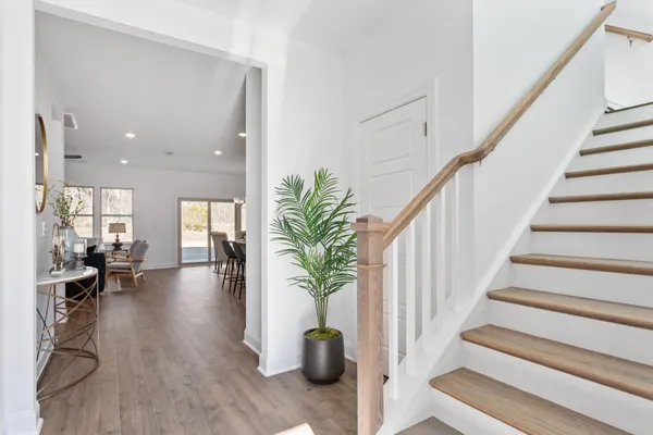 a hallway with wooden floor and a potted plant