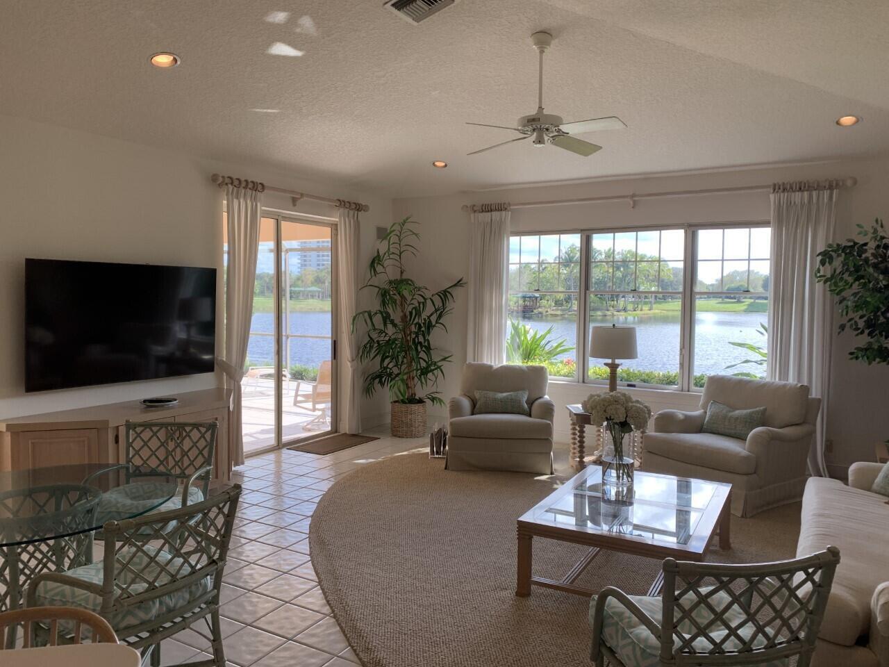 3446 Southern Cay Drive Jupiter, FL 33477 - Photo 4 of 15 a living room with furniture a flat screen tv and a large window