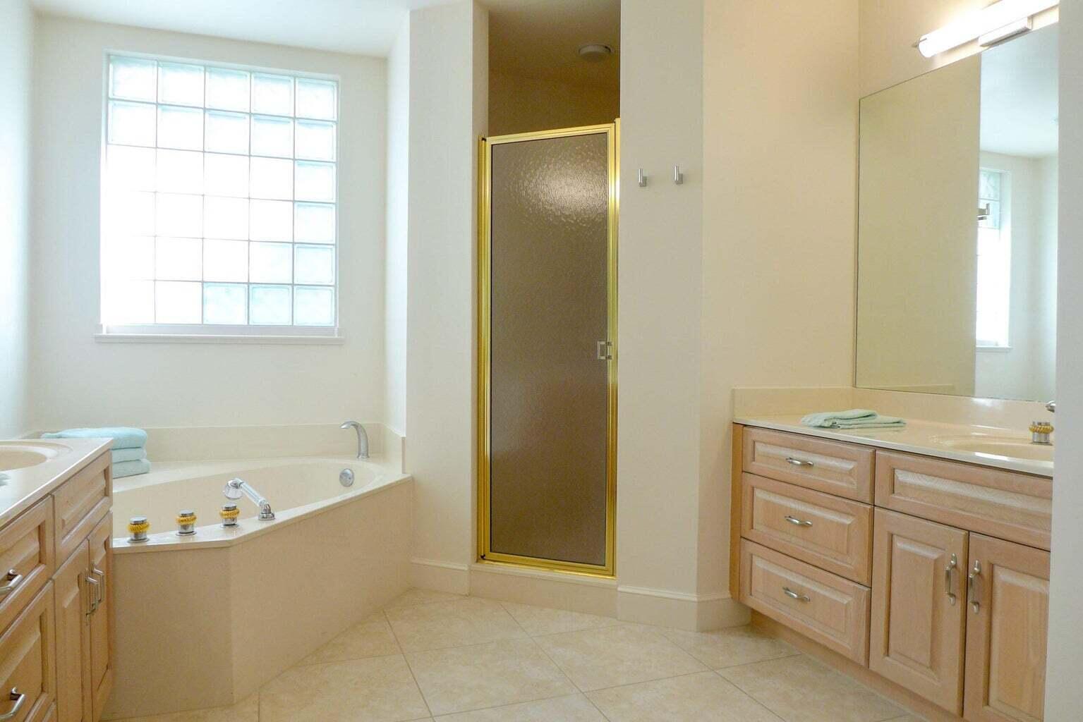 3446 Southern Cay Drive Jupiter, FL 33477 - Photo 7 of 15 a bathroom with a bathtub sink and mirror