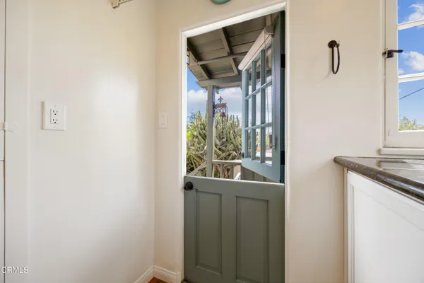 a view of a hallway with wooden floor and a bathroom