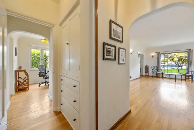 a view of a hallway with furniture and wooden floor