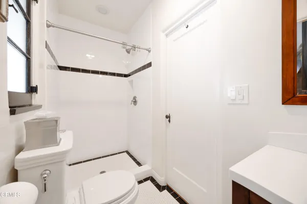 a white toilet sitting next to a bathroom sink and a mirror