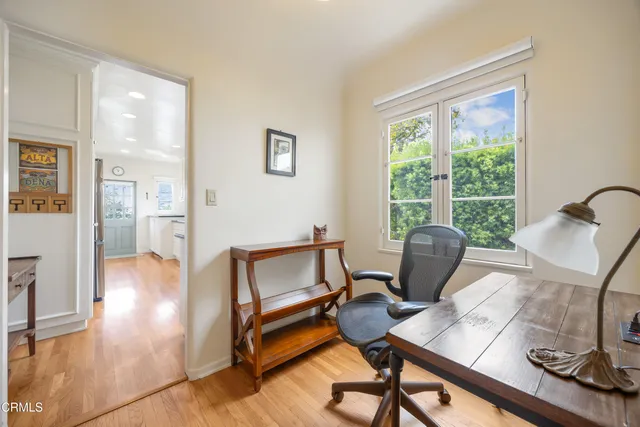a view of a workspace with furniture and a window