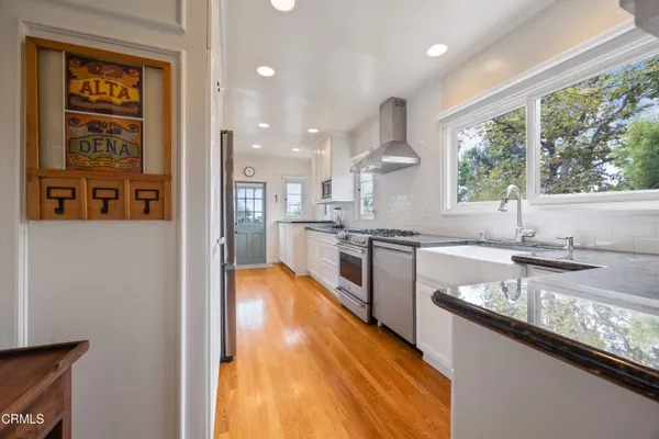 a large kitchen with stainless steel appliances granite countertop a lot of counter space and a sink