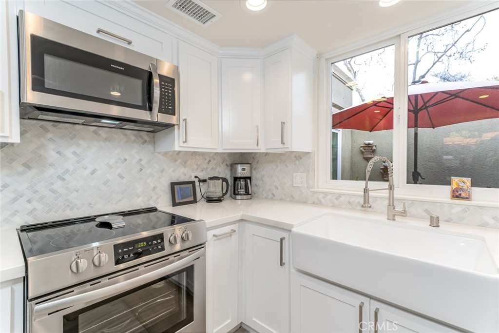 74 Calle Aragon, Unit B Laguna Woods, CA 92637 - Photo 11 of 22 a kitchen with a stove microwave and sink