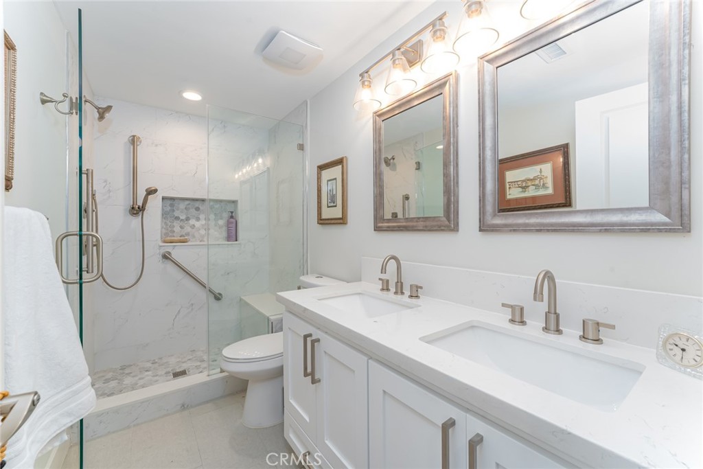 74 Calle Aragon, Unit B Laguna Woods, CA 92637 - Photo 15 of 22 a bathroom with a sink a toilet a mirror and shower