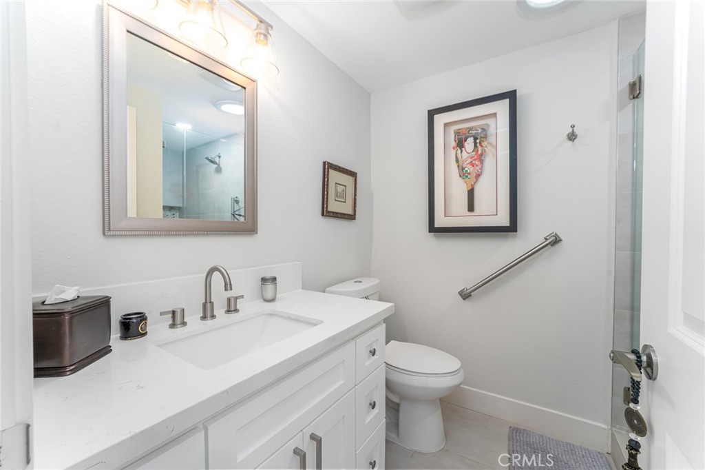 74 Calle Aragon, Unit B Laguna Woods, CA 92637 - Photo 18 of 22 a bathroom with a toilet a sink and mirror
