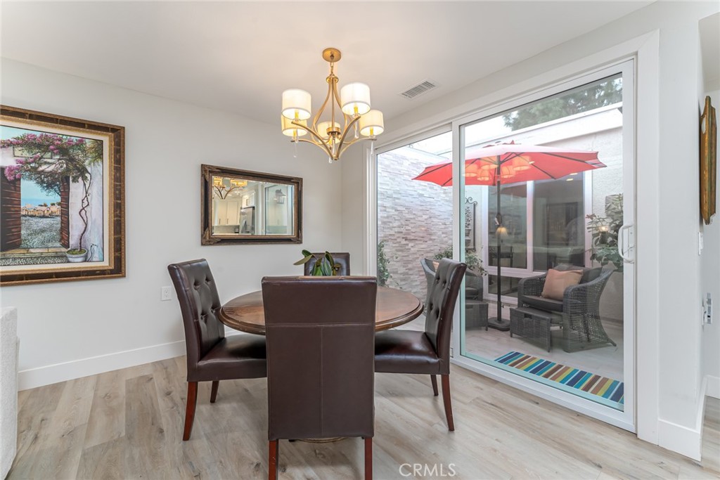 74 Calle Aragon, Unit B Laguna Woods, CA 92637 - Photo 8 of 22 a view of a dining room with furniture wooden floor and a chandelier
