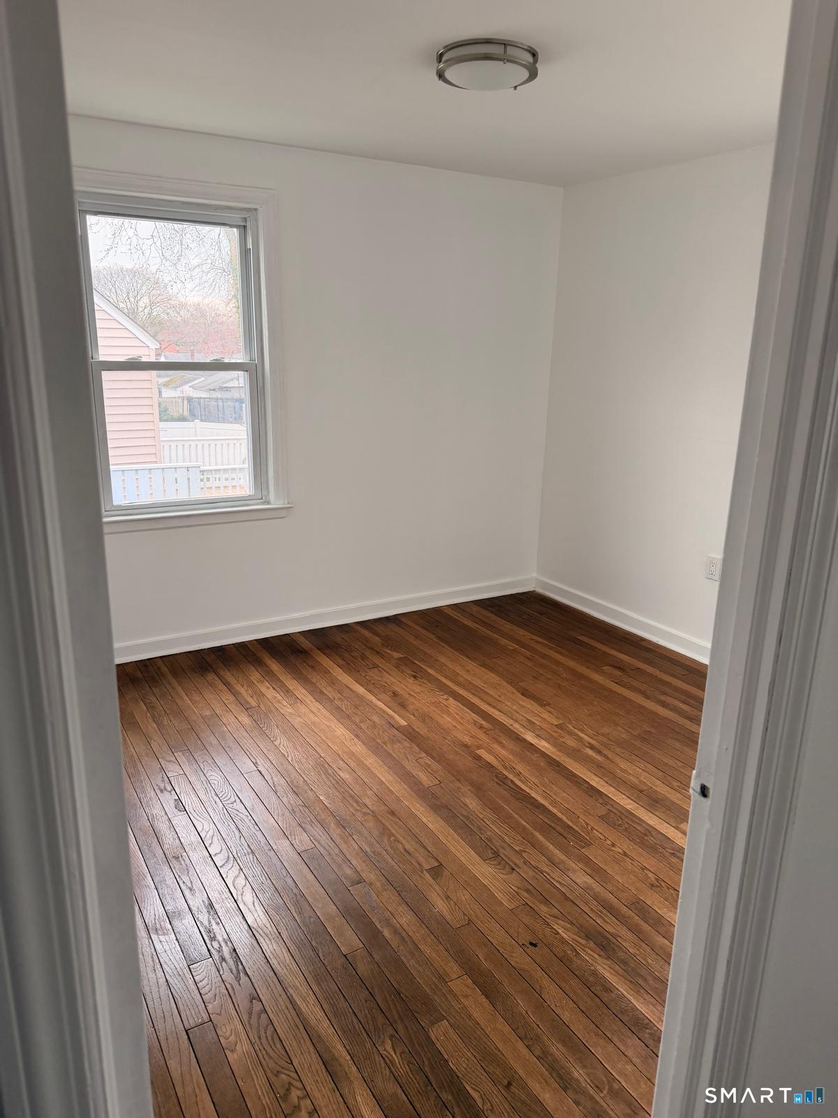 44 Lynmoor Place Hamden, CT 06517 - Photo 17 of 30 an empty room with wooden floor and windows