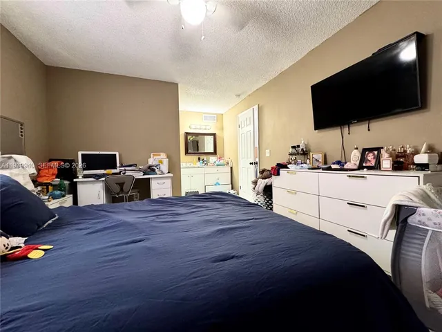 a bedroom with a bed and a flat screen tv