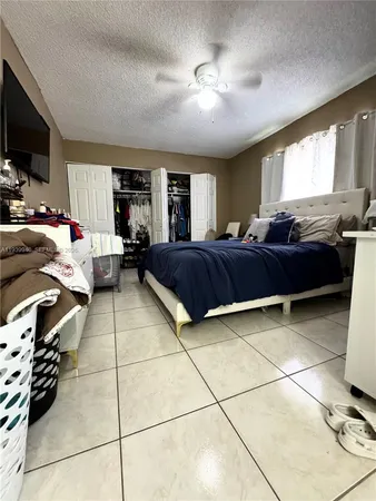 a bedroom with a bed a flat screen tv and couches