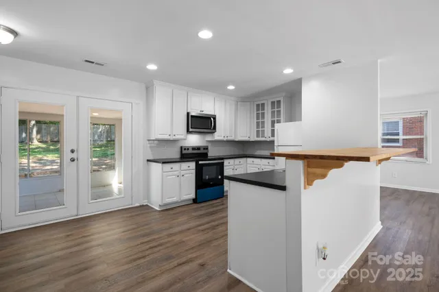 a kitchen with granite countertop white cabinets and stainless steel appliances