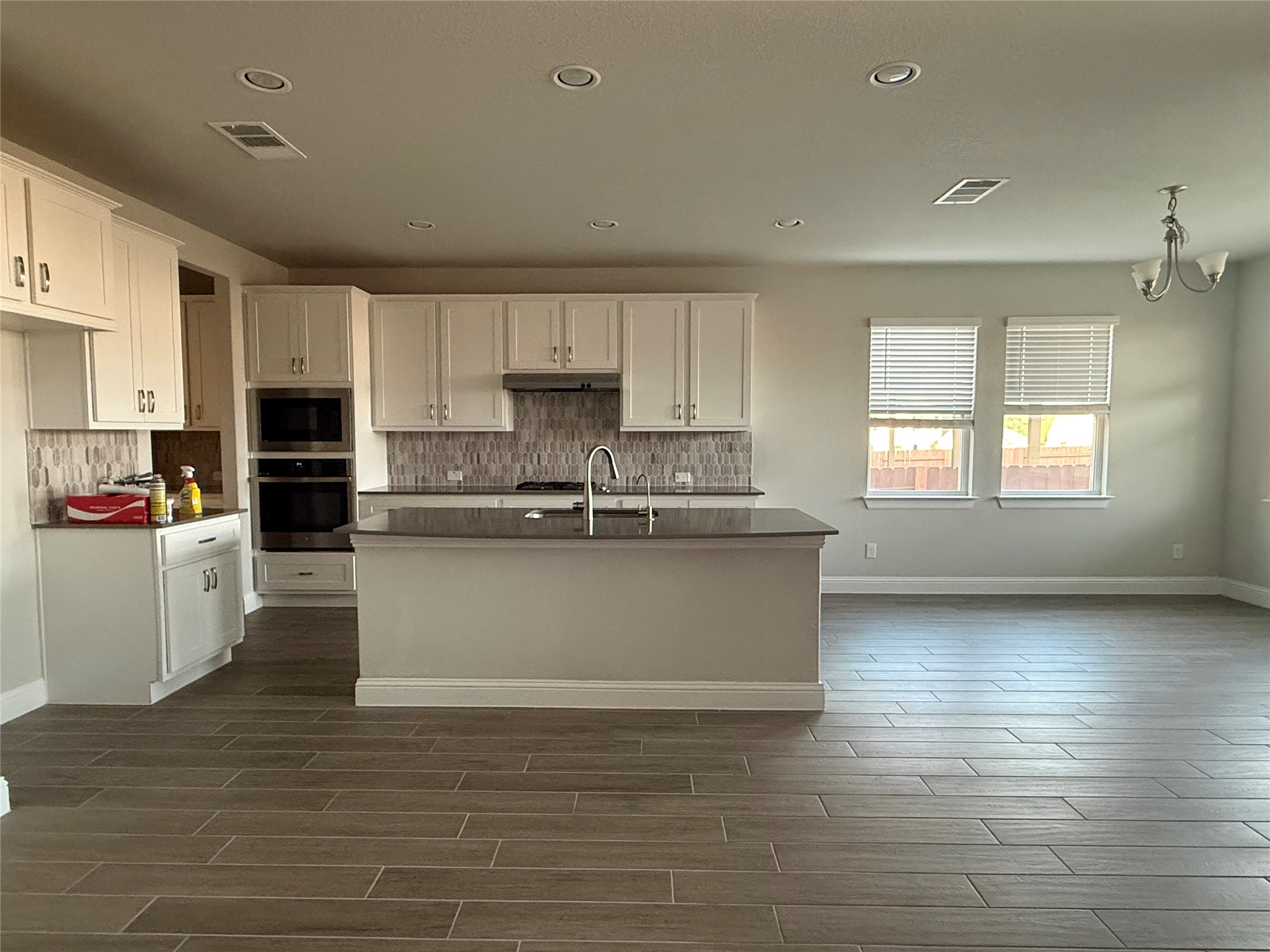 109 Rocky River Road Georgetown, TX 78628 - Photo 6 of 10 A contemporary kitchen and living area featuring sleek cabinetry and a spacious island.