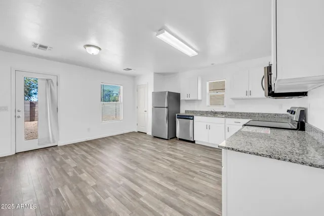 a kitchen with white cabinets and stainless steel appliances