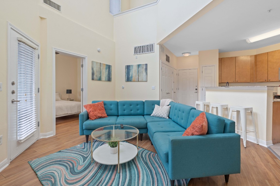2502 Leon Street, Unit 501 Austin, TX 78705 - Photo 7 of 14 Living room featuring light wood-type flooring and a towering ceiling