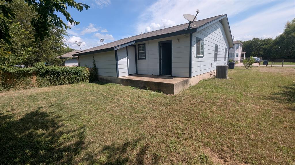 107 Beck Street, Unit B Florence, TX 76527 - Photo 8 of 8 A modest rear facade with a simple concrete patio opens to a sizable, grassy private yard.