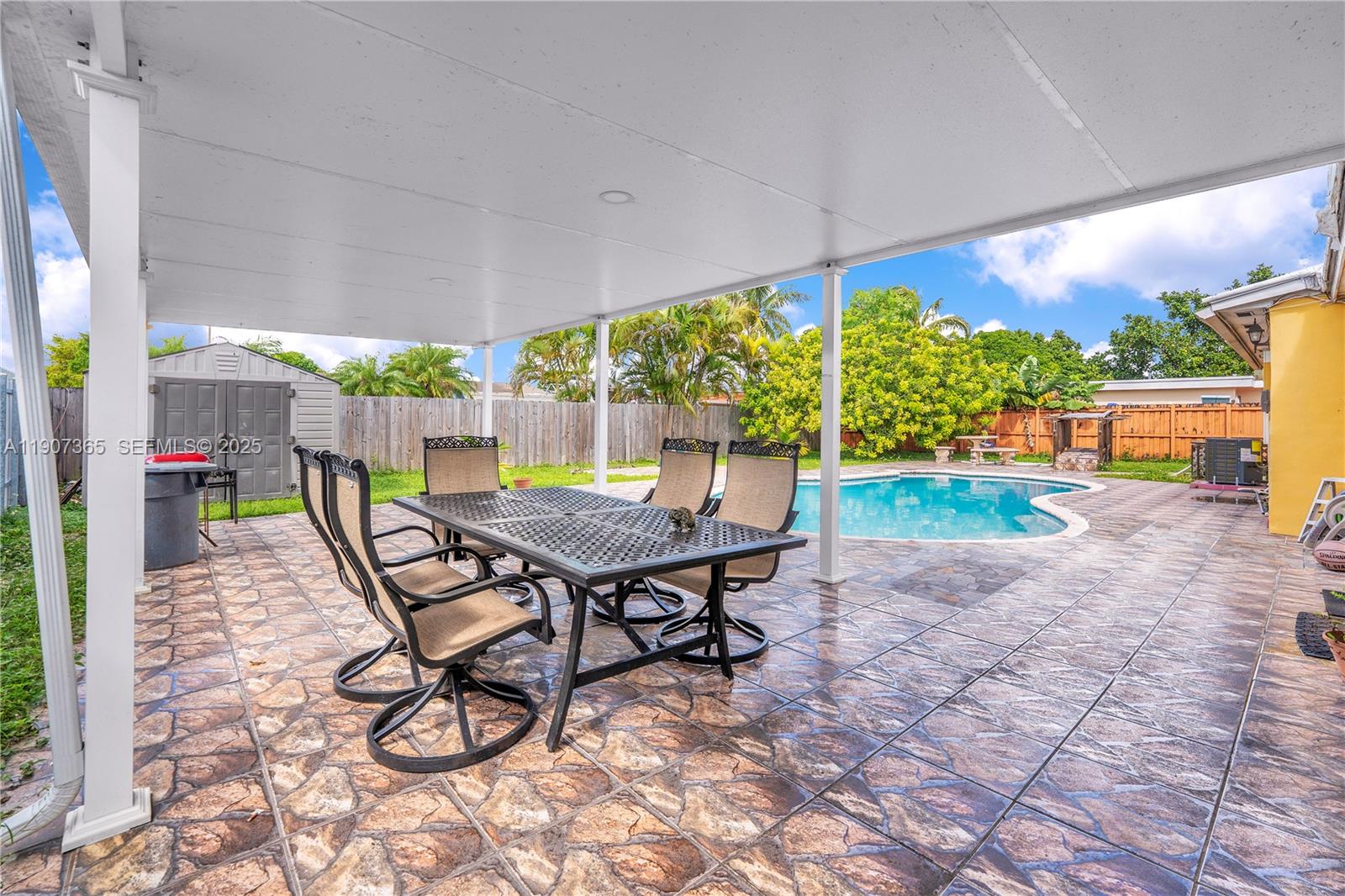 18922 Southwest 120th Court Miami, FL 33177 - Photo 15 of 29 a view of a patio with a table chairs and a backyard