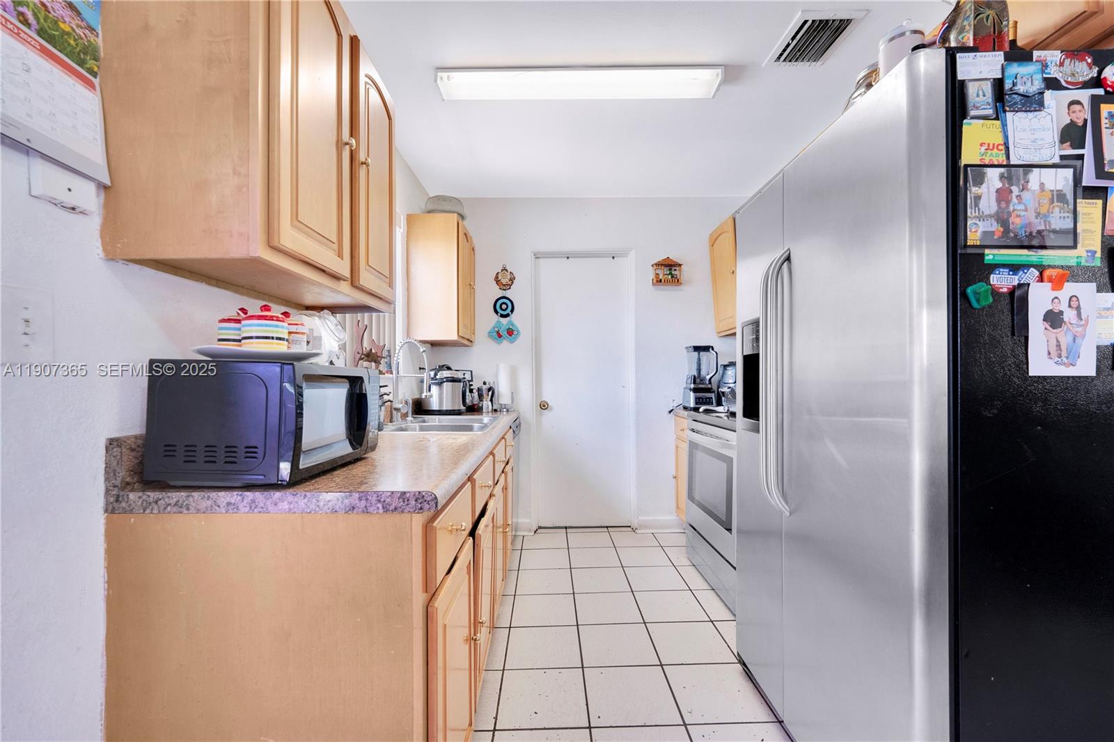 18922 Southwest 120th Court Miami, FL 33177 - Photo 5 of 29 a kitchen with stainless steel appliances a refrigerator sink and cabinets
