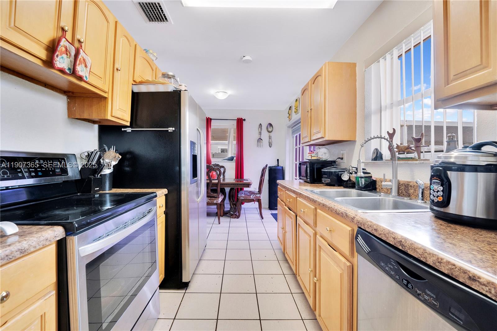 18922 Southwest 120th Court Miami, FL 33177 - Photo 6 of 29 a kitchen with stainless steel appliances granite countertop a stove top oven a sink a counter space and cabinets