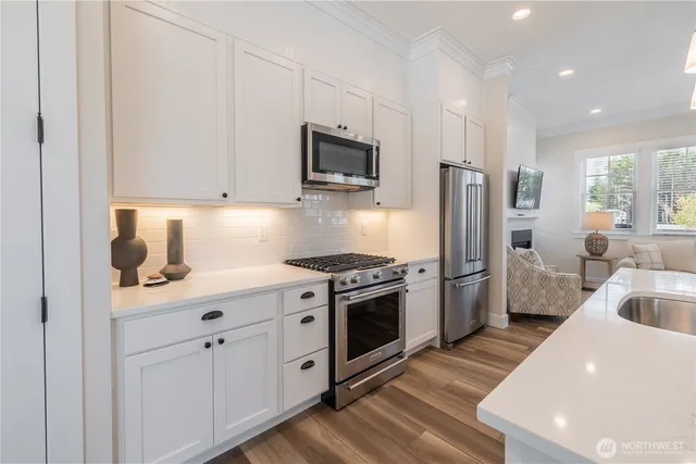 a kitchen with stainless steel appliances granite countertop a sink stove and refrigerator