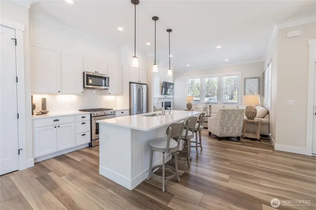 a kitchen with stainless steel appliances kitchen island granite countertop a sink a stove and a refrigerator