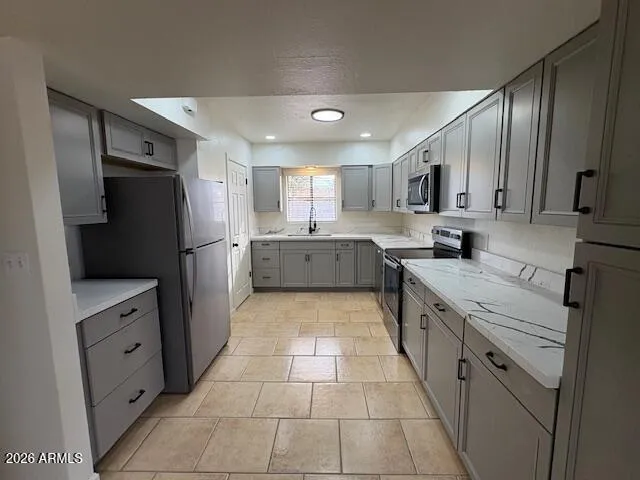 a large kitchen with stainless steel appliances kitchen island granite countertop a refrigerator and a sink