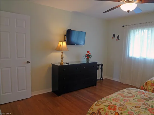 a bed room with a bed and a lamp on dresser